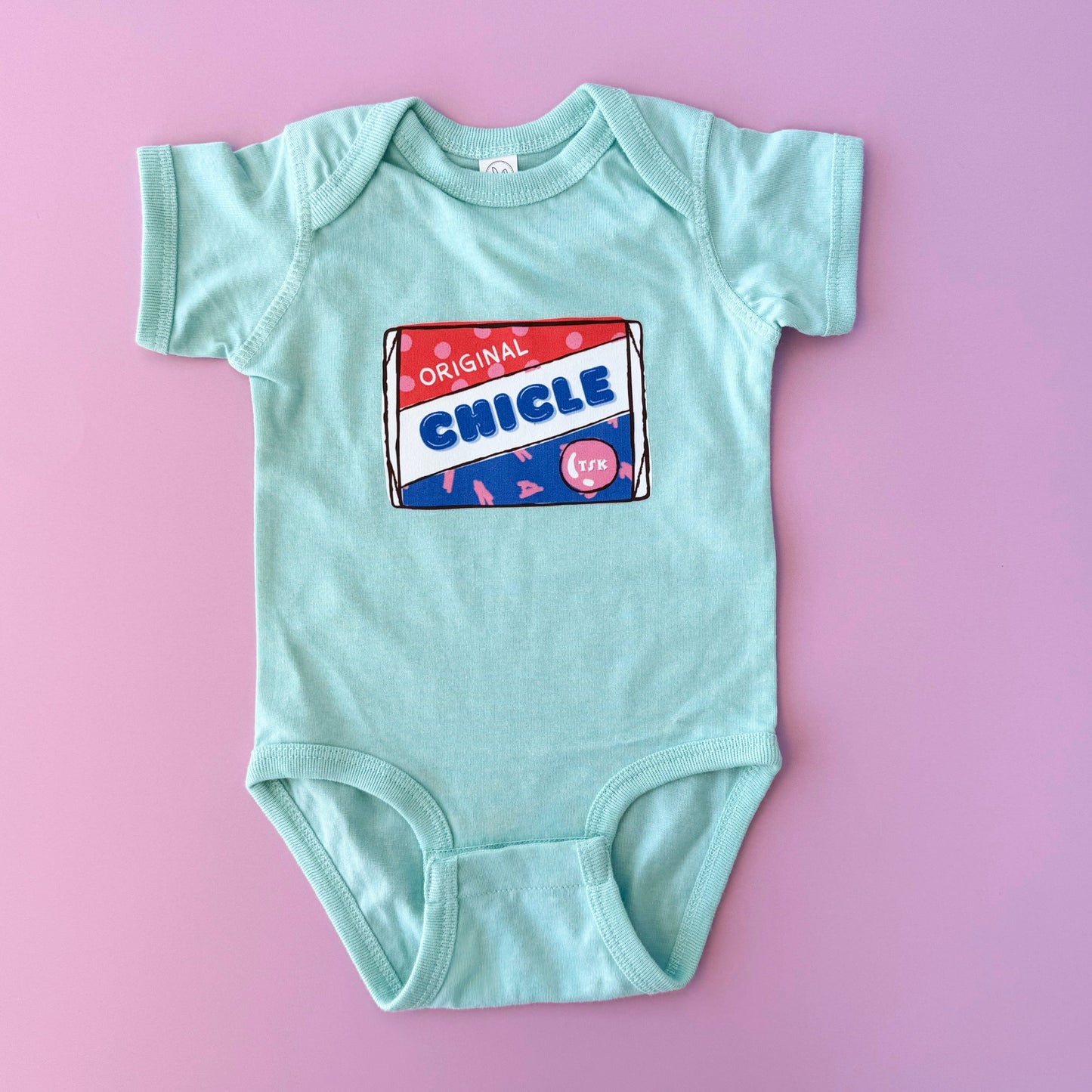 Light blue baby onesie with a colorful 'Chicle' label on a pink background